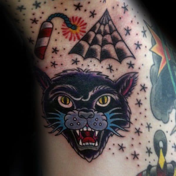 Tattoo of a snarling black cat with a lit firecracker, spiderweb, and starry details, creating a bold, classic Halloween-inspired design.
