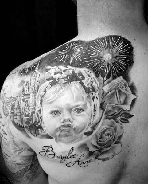 Black and grey tattoo featuring a realistic portrait of a child, fireworks, roses, and a castle, with the name "Braylee Anne" in script.