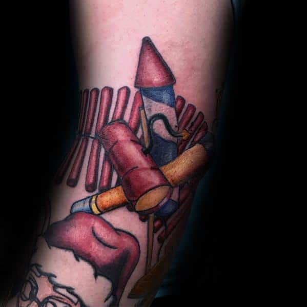 Tattoo featuring a bundle of fireworks, including rockets and firecrackers, designed with bold colors and shading for a dynamic and explosive look.