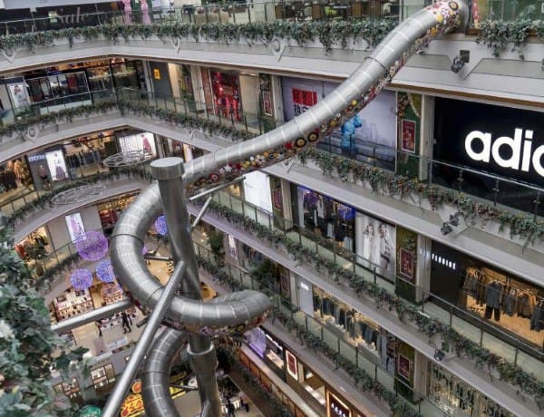 A multi-level mall featuring a large spiral slide winding through the atrium