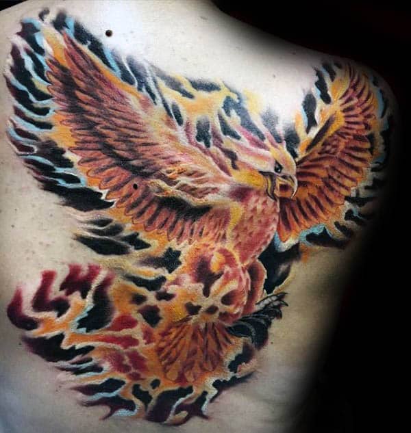 Tattoo of a colorful, fiery phoenix spread across a person's back