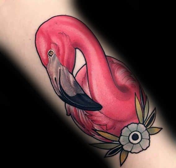 Traditional-style flamingo tattoo with bold pink hues, fine shading, and floral details, creating a classic yet elegant design.