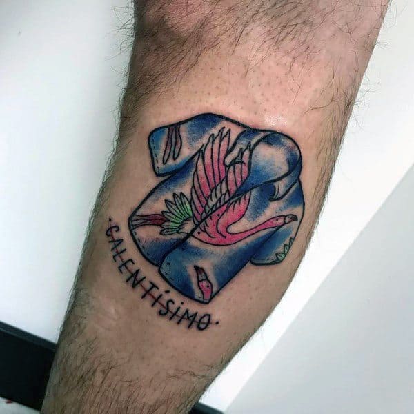 Unique flamingo tattoo featuring a folded shirt design with a tropical flamingo print and the word "Calentísimo," blending fashion and art.