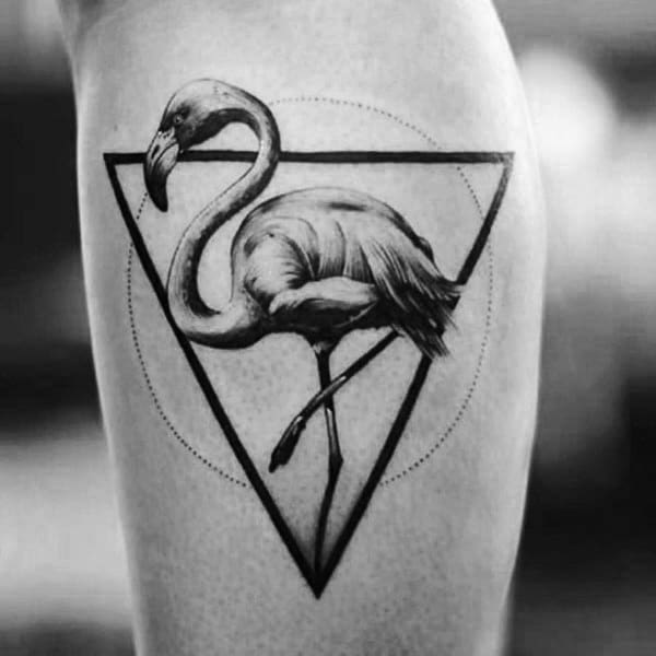 Black and grey realistic flamingo tattoo with fine shading, enclosed in a geometric triangle, blending nature with modern design.