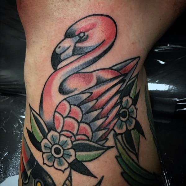 Neo-traditional flamingo tattoo with bold outlines, soft shading, and floral accents, blending classic and modern tattoo styles.