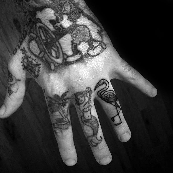 Small black flamingo tattoo on the finger, done in a simple linework style, adding a quirky and bold touch to a hand tattoo collection.
