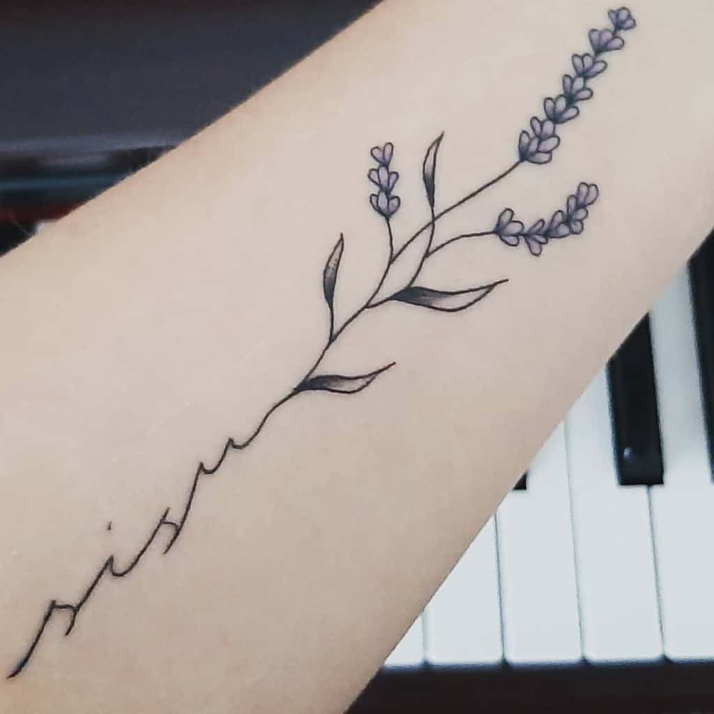 A delicate lavender tattoo along the forearm with thin linework and subtle purple flowers, accompanied by the word "sisu" in cursive script.