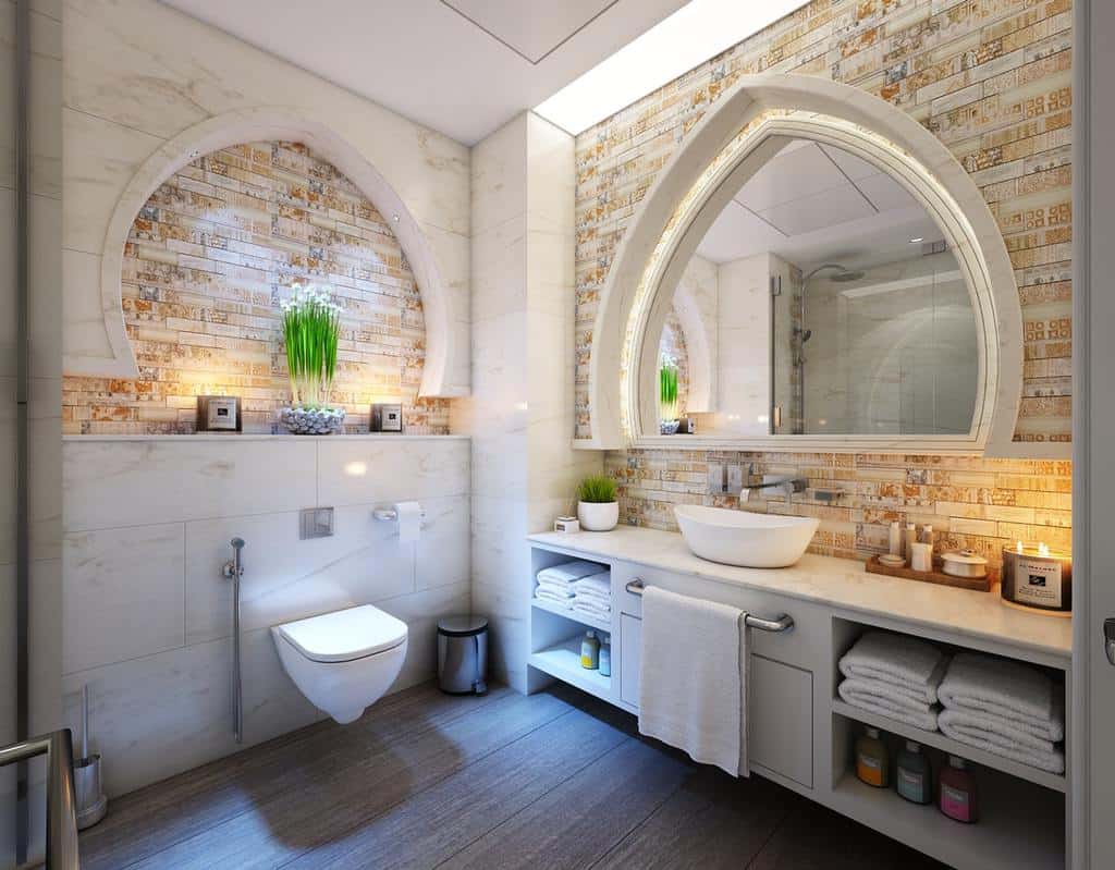 Modern bathroom with arched mirror, floating vanity, and decorative marble accents.