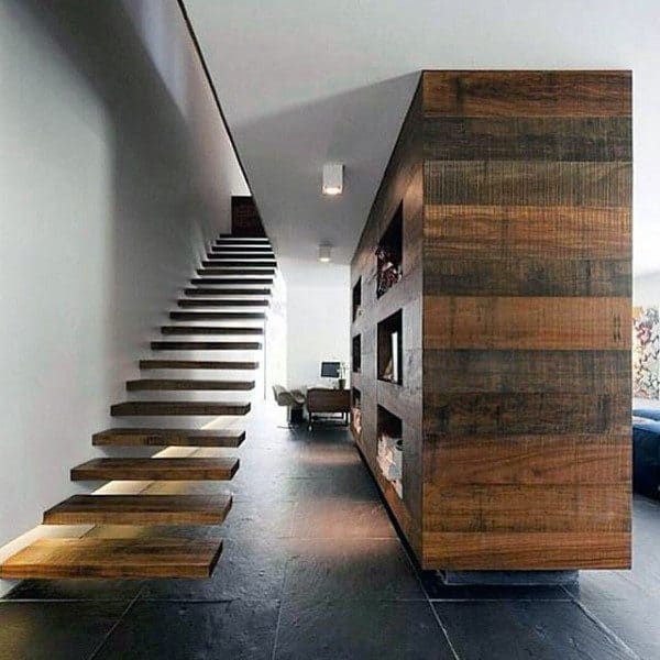 Modern interior with floating wooden staircase, dark slate floor, and built-in wooden shelves