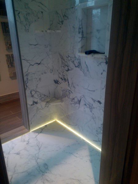 Luxurious marble shower with soft LED lighting along the floor, creating a serene and sophisticated atmosphere