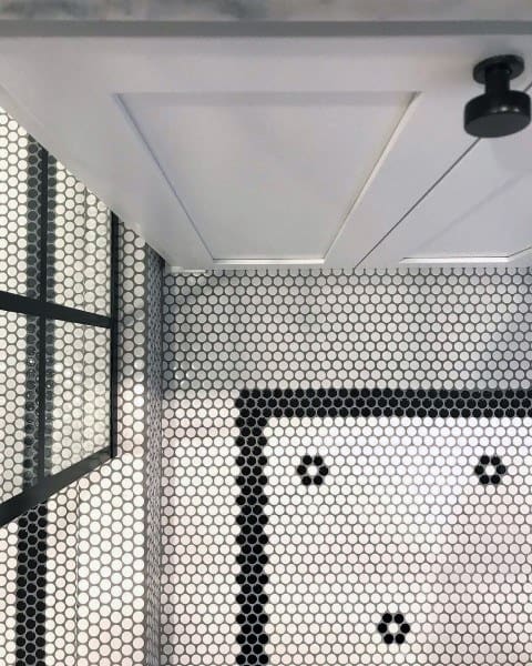 Bathroom with black and white hexagonal mosaic floor tiles featuring a patterned border design.