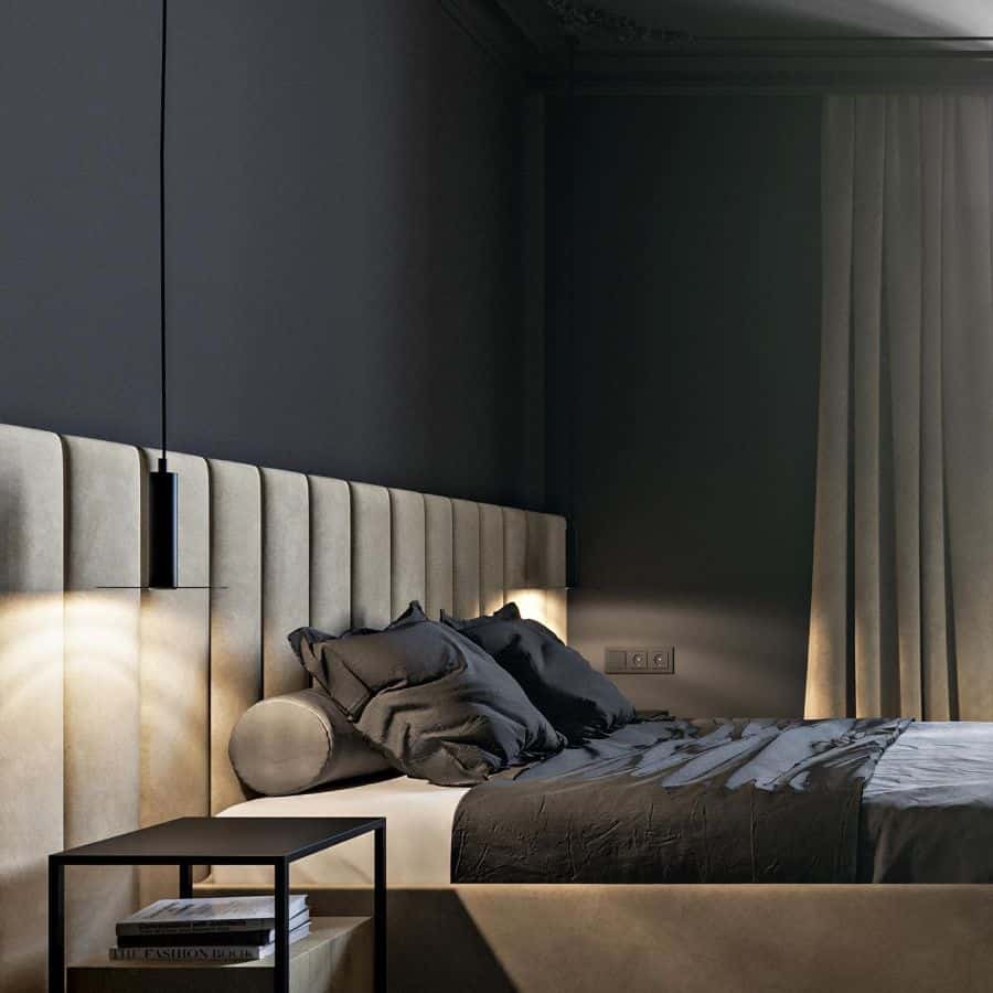 Modern bedroom with black walls, beige headboard, and minimalist pendant light.