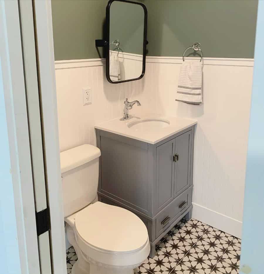 dual green and white wall powder room with pattern floor tiles