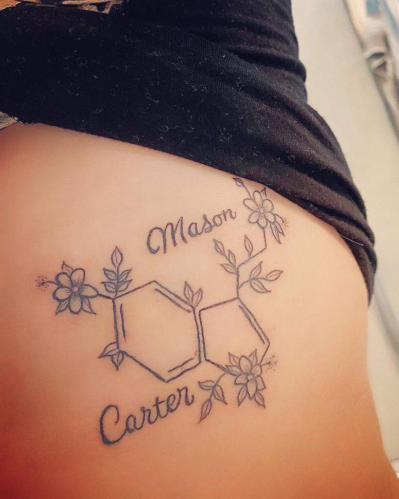 Tattoo of a serotonin molecular structure with floral accents, beautifully interwoven with the names "Mason" and "Carter"