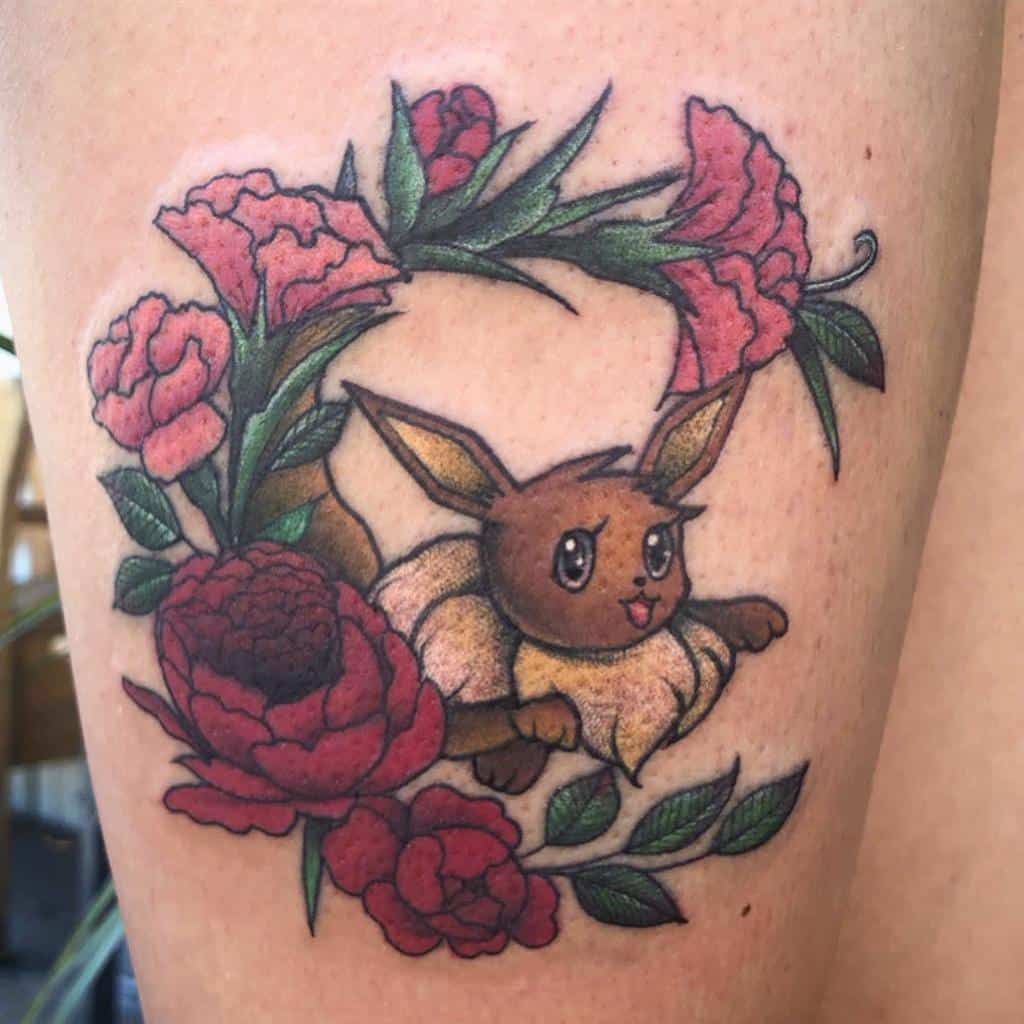 Tattoo of a cartoon Eevee surrounded by pink flowers and green leaves on a thigh