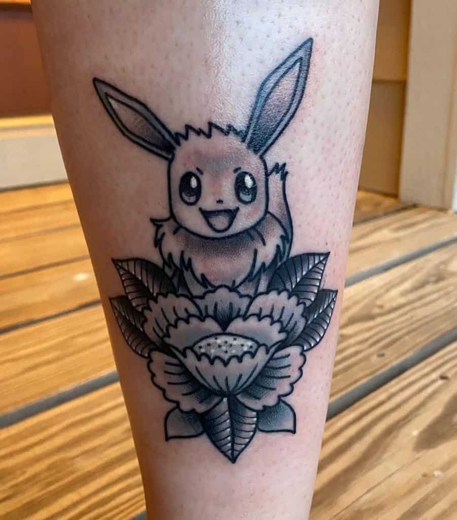 Bold black and grey Eevee tattoo with intricate floral details, combining charm with classic monochrome shading