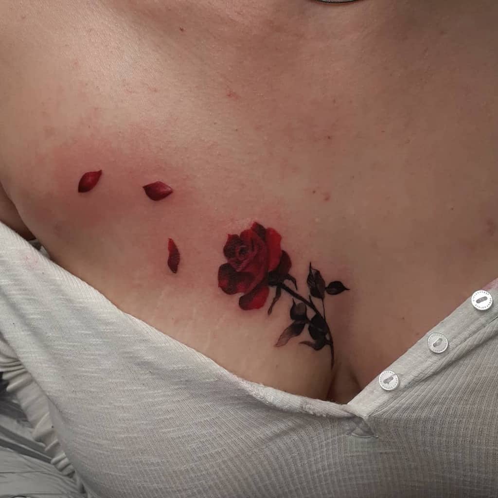 A realistic red rose tattoo with falling petals