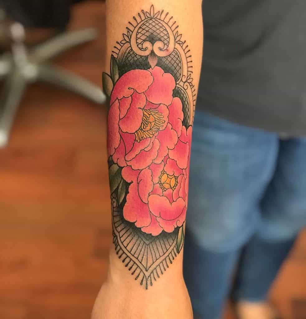 Forearm tattoo featuring vibrant pink peonies with intricate black lace patterns and ornamental filigree details.