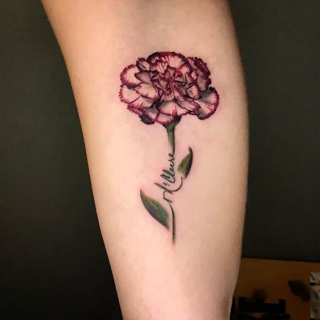 Tattoo of a red carnation with green leaves and the word "believe" on forearm