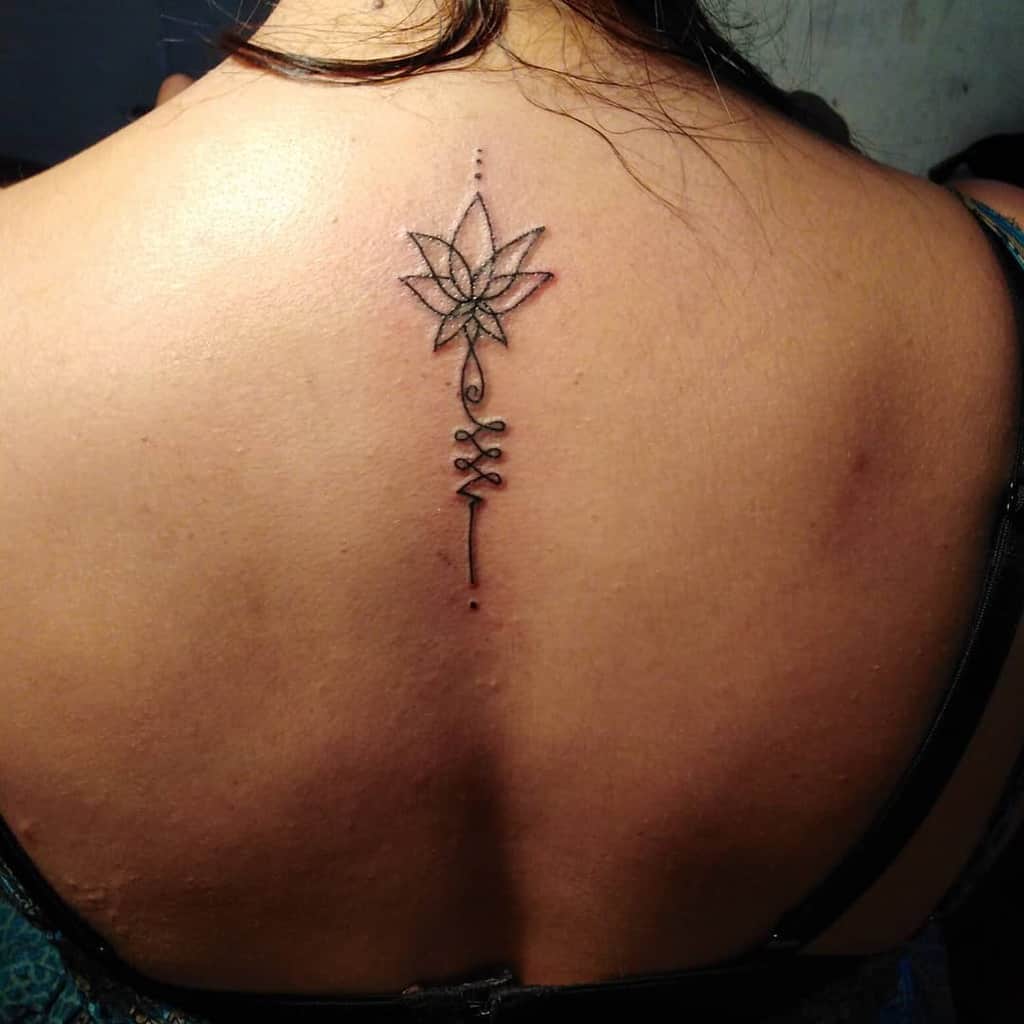 Unalome tattoo with a lotus on the upper back, symbolizing spiritual enlightenment, personal growth, and the journey to inner peace.