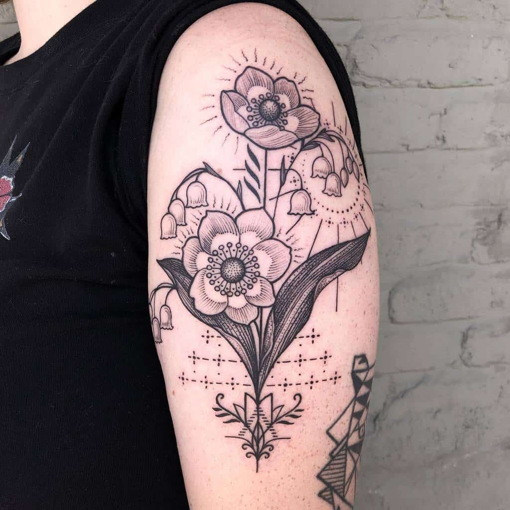 Ornate black ink tattoo of Lily of the Valley and other floral elements, featuring geometric patterns and fine line details