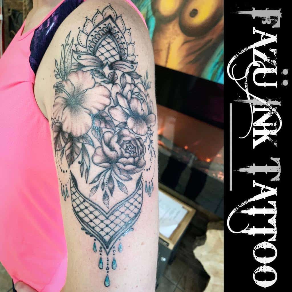 Intricate floral tattoo on upper arm with geometric patterns and beads
