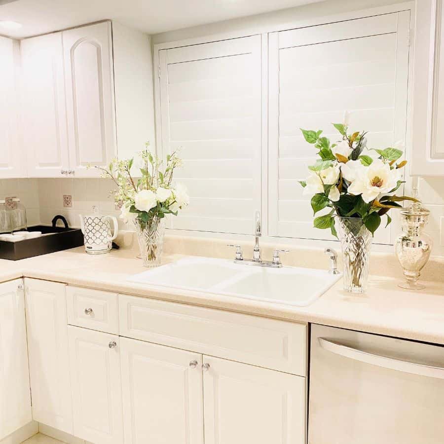 white kitchen with two vases with white flowers