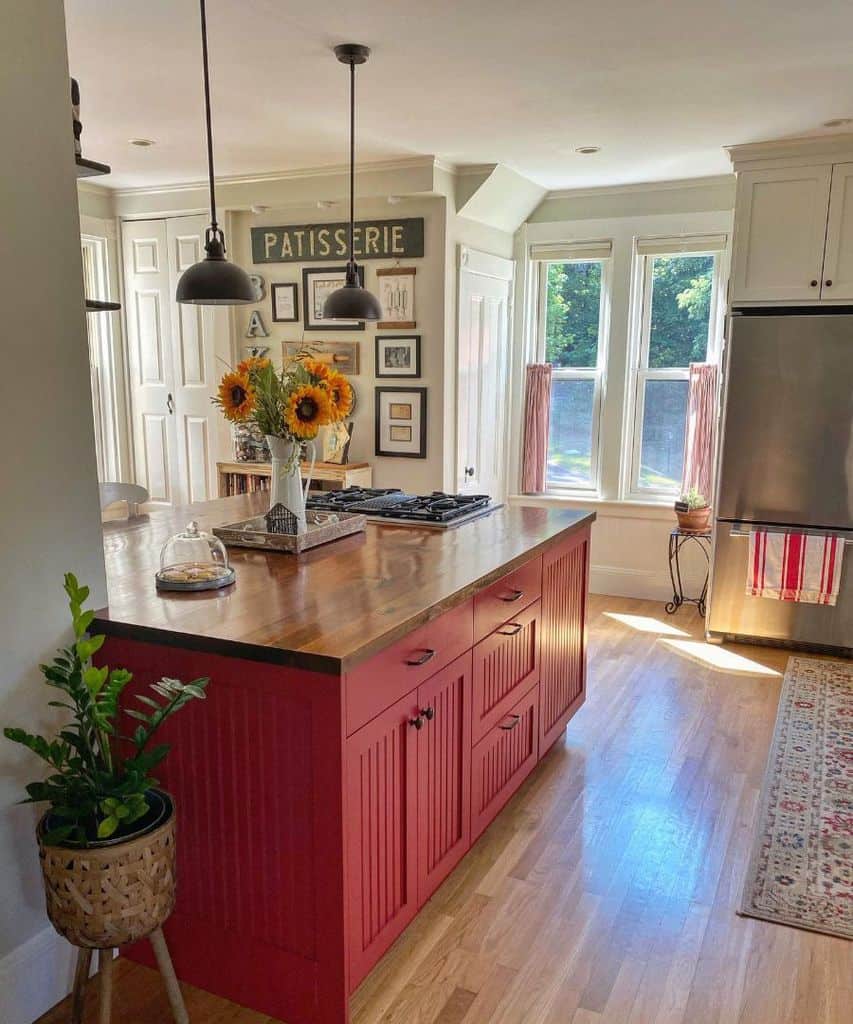 Cozy kitchen with red island wood countertop pendant lights and sunflower centerpiece.