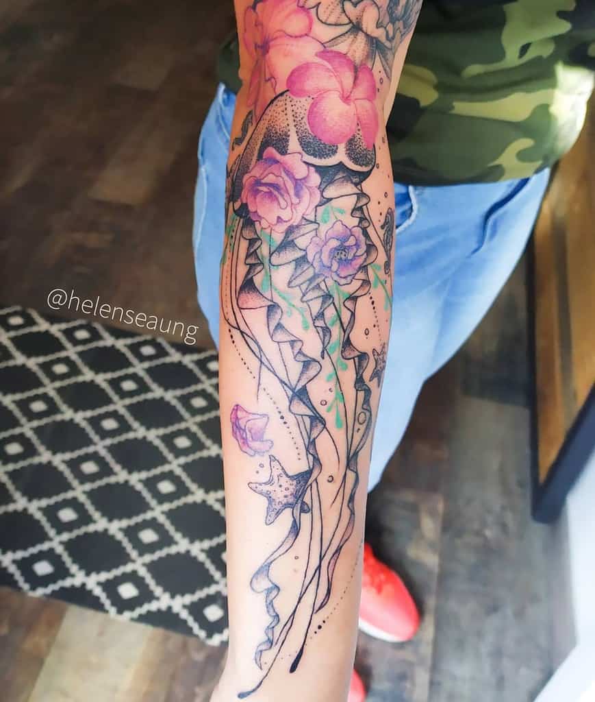 Forearm tattoo of jellyfish and flowers, with vibrant colors and intricate details