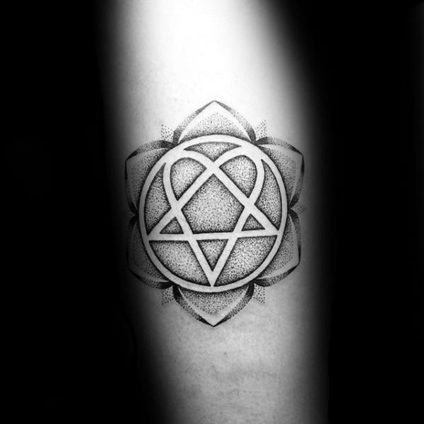 Tattoo of a symmetrical symbol with heart, triangle, and circle elements on a flower background with dot shadings