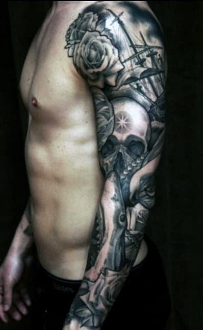 Man with detailed full sleeve tattoo featuring a skull, roses, and various designs