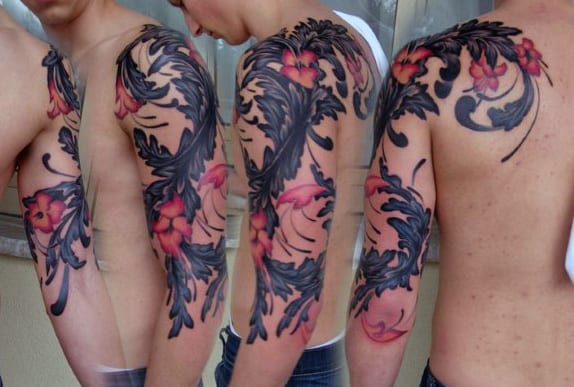 Floral and leaf tattoo sleeve in red and black on an arm