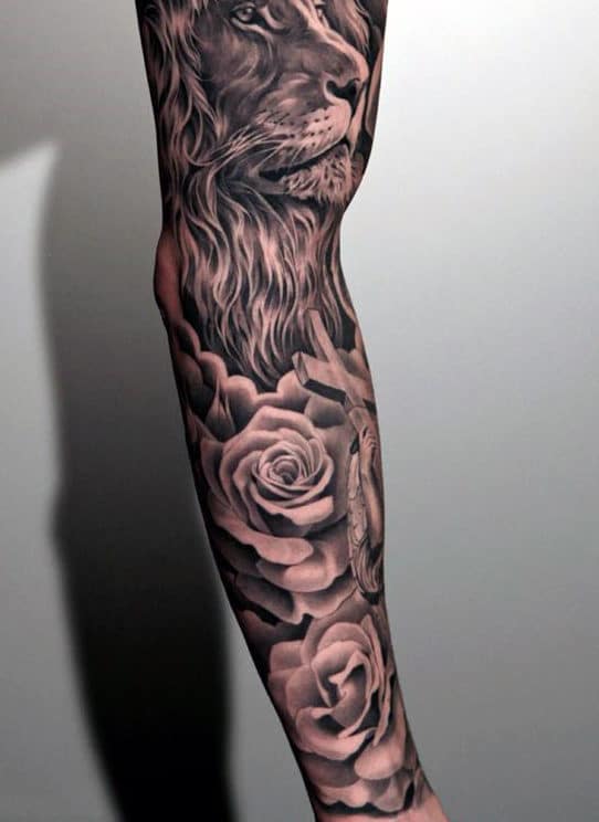 A tattoo of a lion and roses covering a person's arm