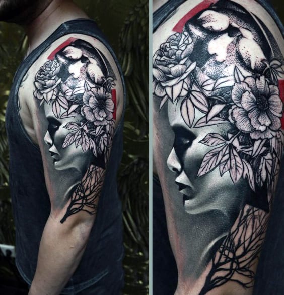 Black and grey tattoo of a woman's face with flowers on a person's upper arm