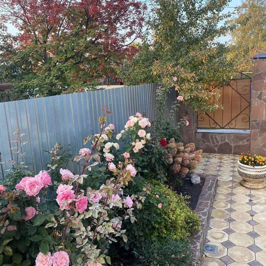 flower bed along metal fence paved patio