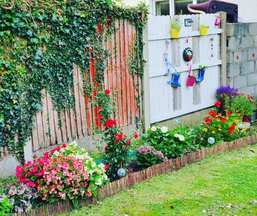 colorful flower bed along backyard fence