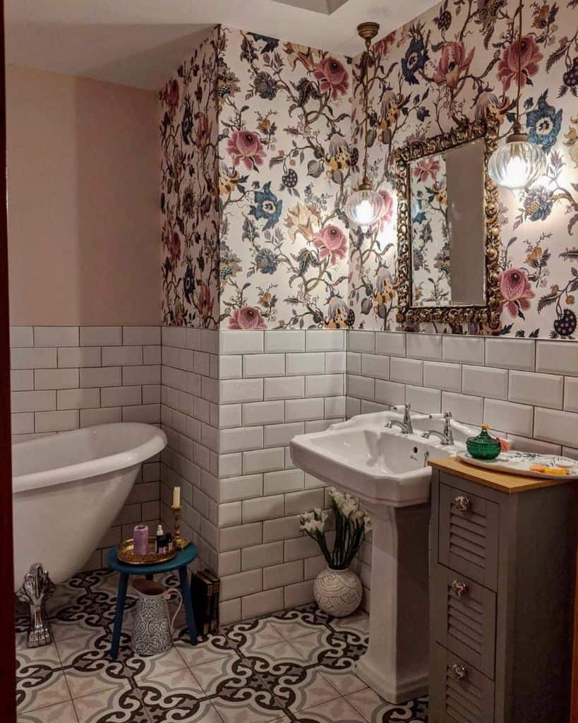 Bathroom with floral wallpaper, clawfoot tub, pedestal sink, and patterned tile floor.