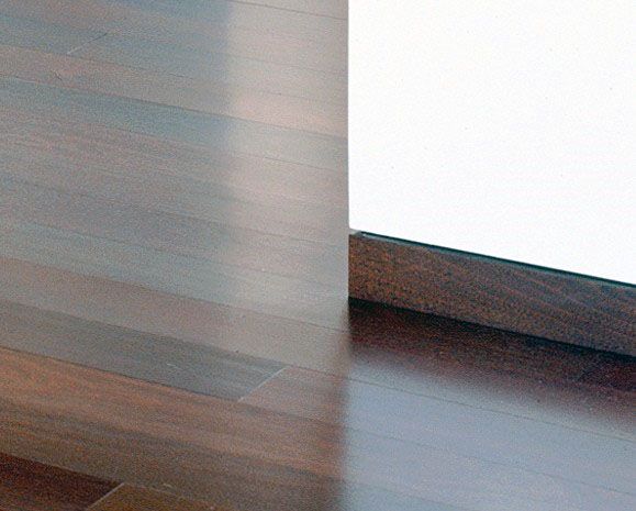 Flush dark wood baseboard with seamless transition to matching hardwood flooring.