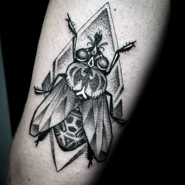 Dotwork fly tattoo with geometric shading and bold outlines, set against an angular diamond-shaped background for a modern edge.