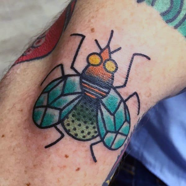 Bright and bold geometric fly tattoo with teal wings, orange head, and dotted green abdomen, outlined in thick black ink.