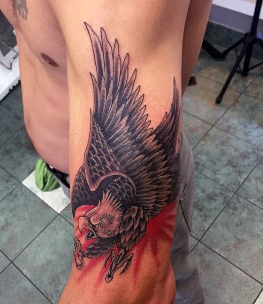 A detailed eagle tattoo with spread wings on a person's upper arm