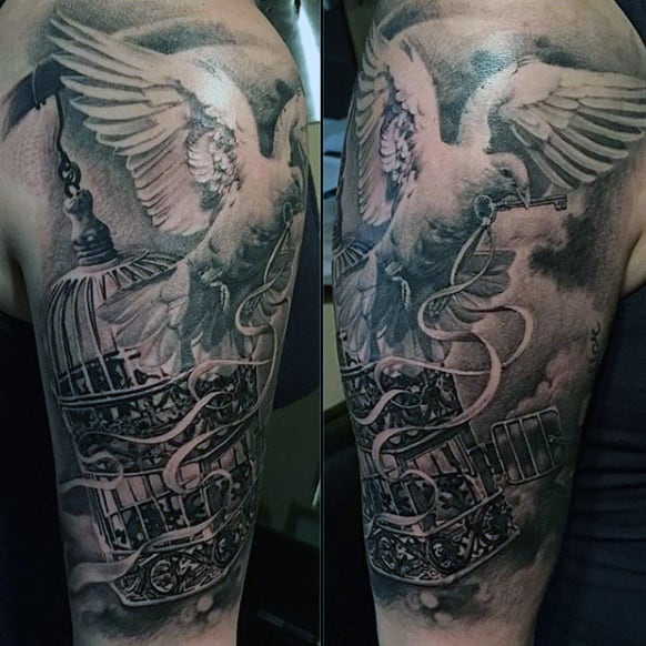 Tattoo of a dove with a key flying away from an open birdcage on an upper arm