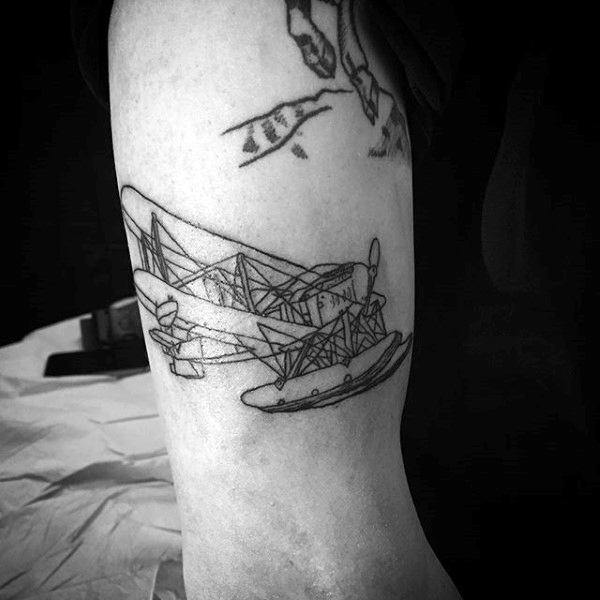 Black line tattoo of a biplane on an upper arm