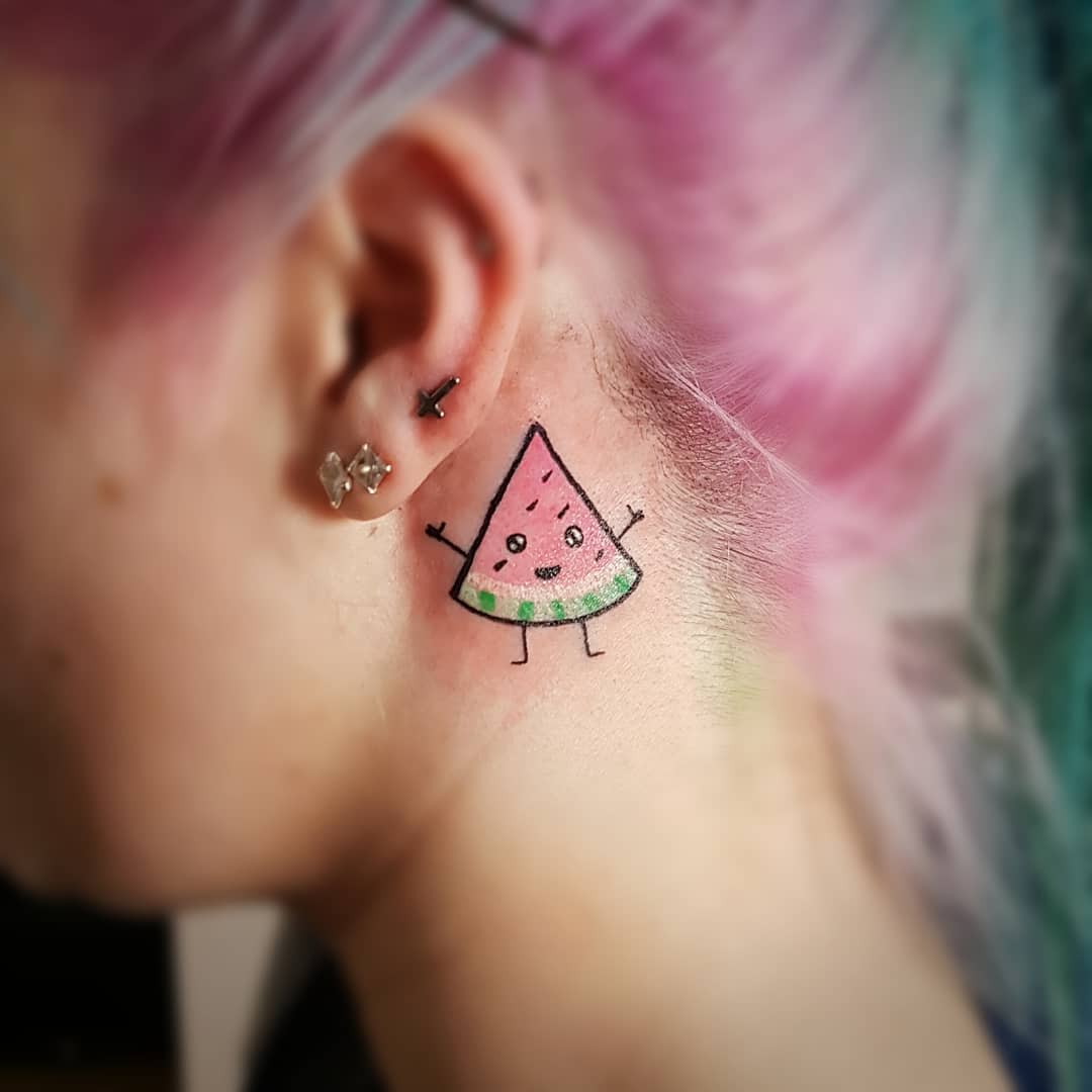 Tattoo of a smiling cartoon watermelon slice