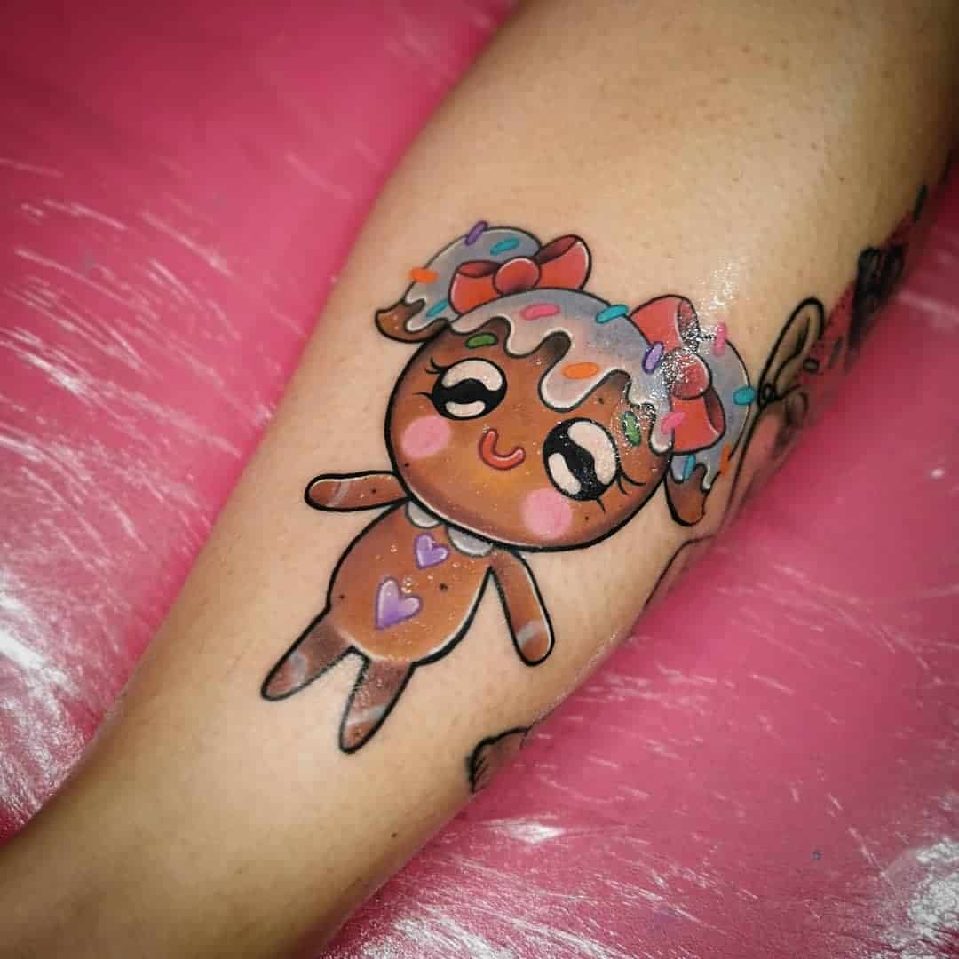 Tattoo of a cute, stylized girl character with rainbow frosting hair and heart accents