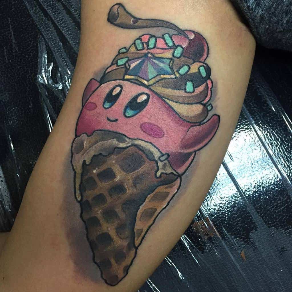 Kirby tattoo designed as an ice cream cone, with chocolate swirls, sprinkles, cherry and a star jewel-topped crown