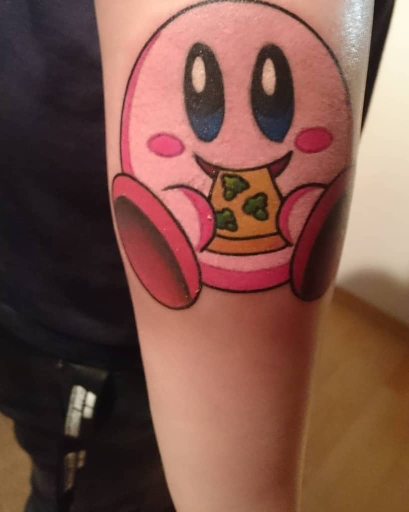 Kirby tattoo happily eating a slice of pizza with green toppings