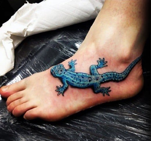 Lifelike blue gecko tattoo on foot with 3D effect, detailed scales, and realistic shadow for a crawling appearance.