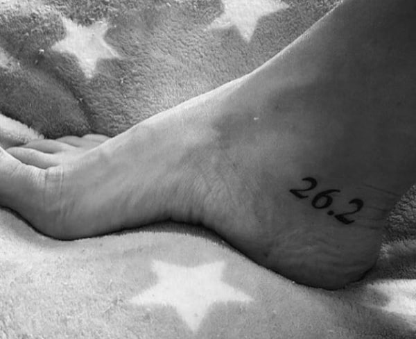 Clean 26.2 tattoo on the side of the heel, a subtle yet powerful tribute to completing a full marathon.