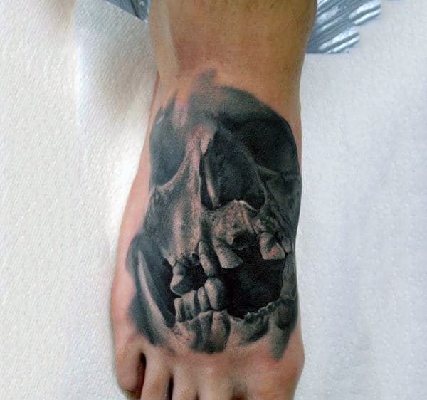 A realistic tattoo of a skull on the top of a foot